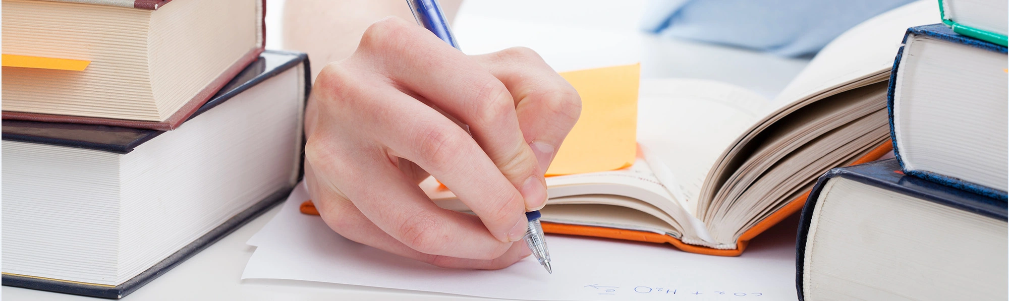 a person writing something on a paper using a pen