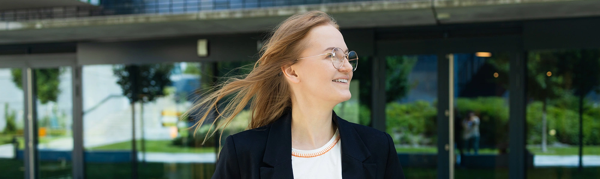 a woman wearing suite standing in front of a college