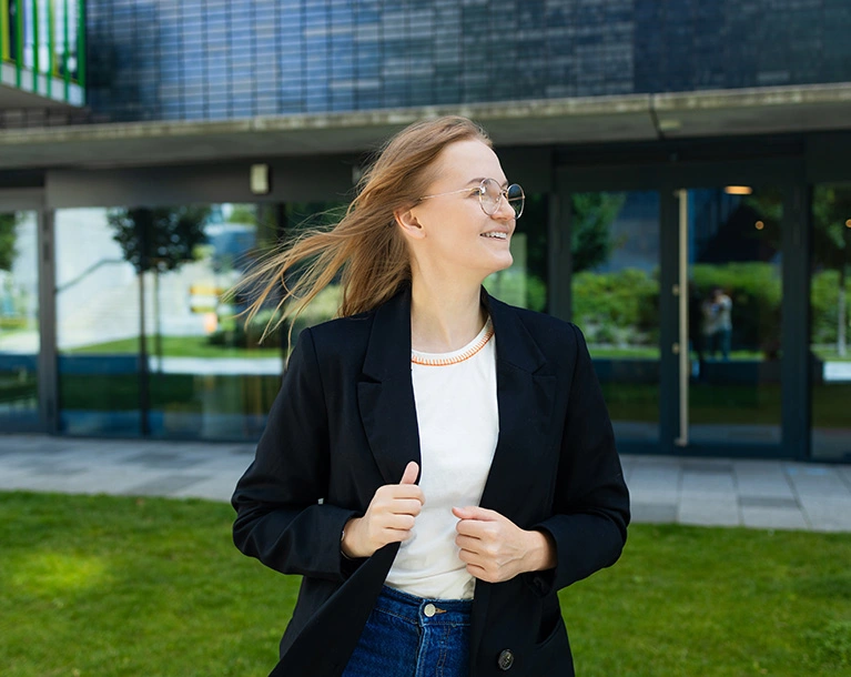 a woman wearing suite standing in front of a college